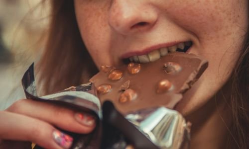 boca de mujer comiendo una tableta de chocolate