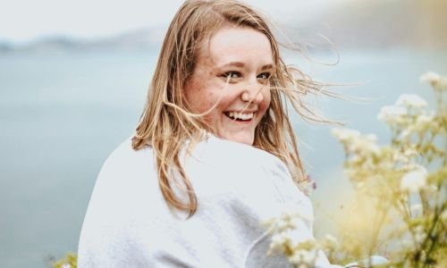 foto de una mujer sonriendo en un paisaje con autoestima