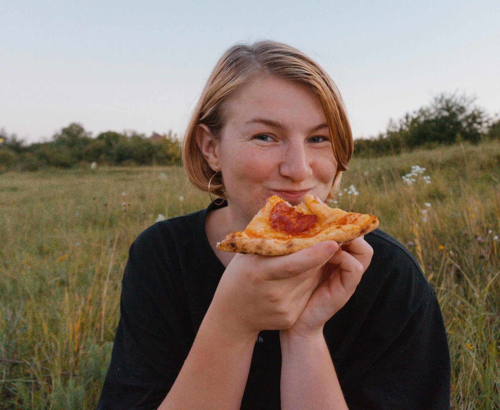 mujer comiendo pizza feliz,reconciliada con la comida nutricionista online